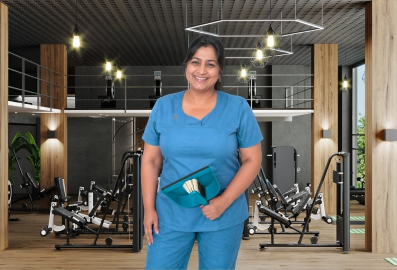 Reinigungskraft der Glanzbrigade Gebäudereinigung bei der Fitnesscenter-Reinigung in Wiesbaden mit Kehrschaufel