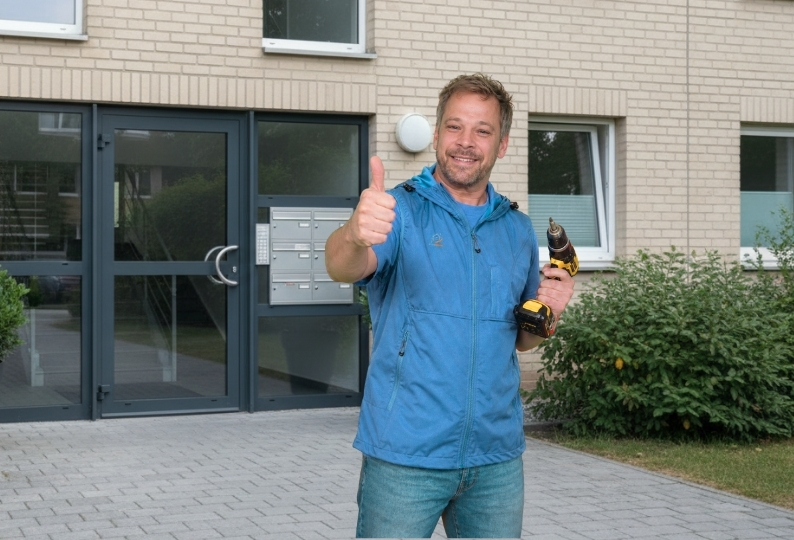 Reinigungskraft der Glanzbrigade Gebäudereinigung bei dem Hausmeisterservice in Wiesbaden mit Kehrschaufel